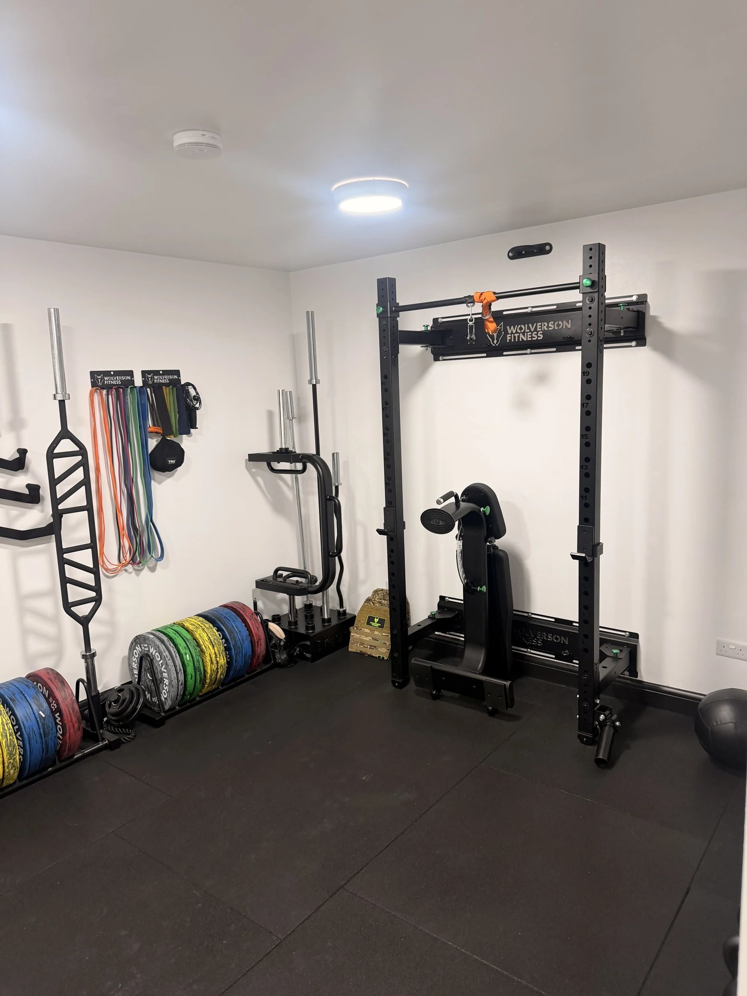 Squat rack, bench and Olympic bars on the training floor at OSHPerformance gym, Northwood